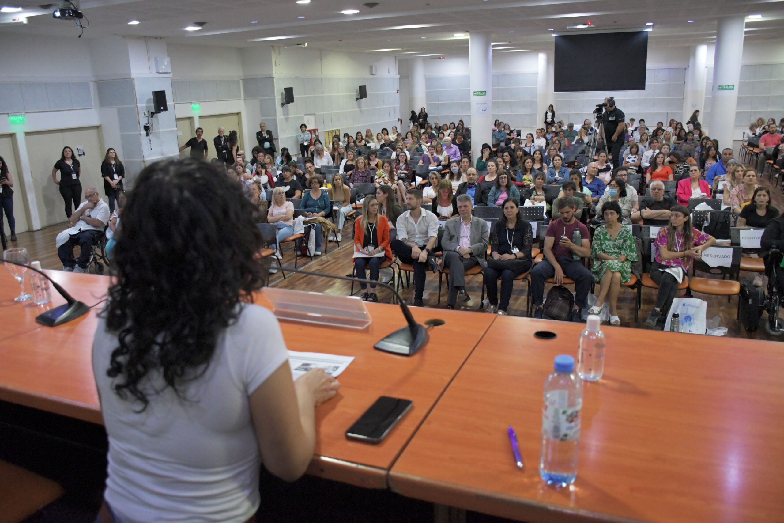 Celeste Pavez sentada frente al público en el auditorio, exponiendo su presentación.